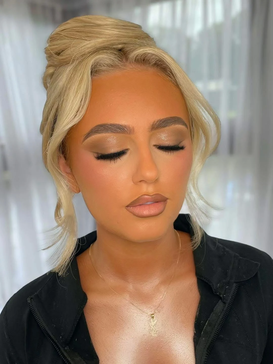 Softly blended eye makeup and a warm nude lip on a blonde client