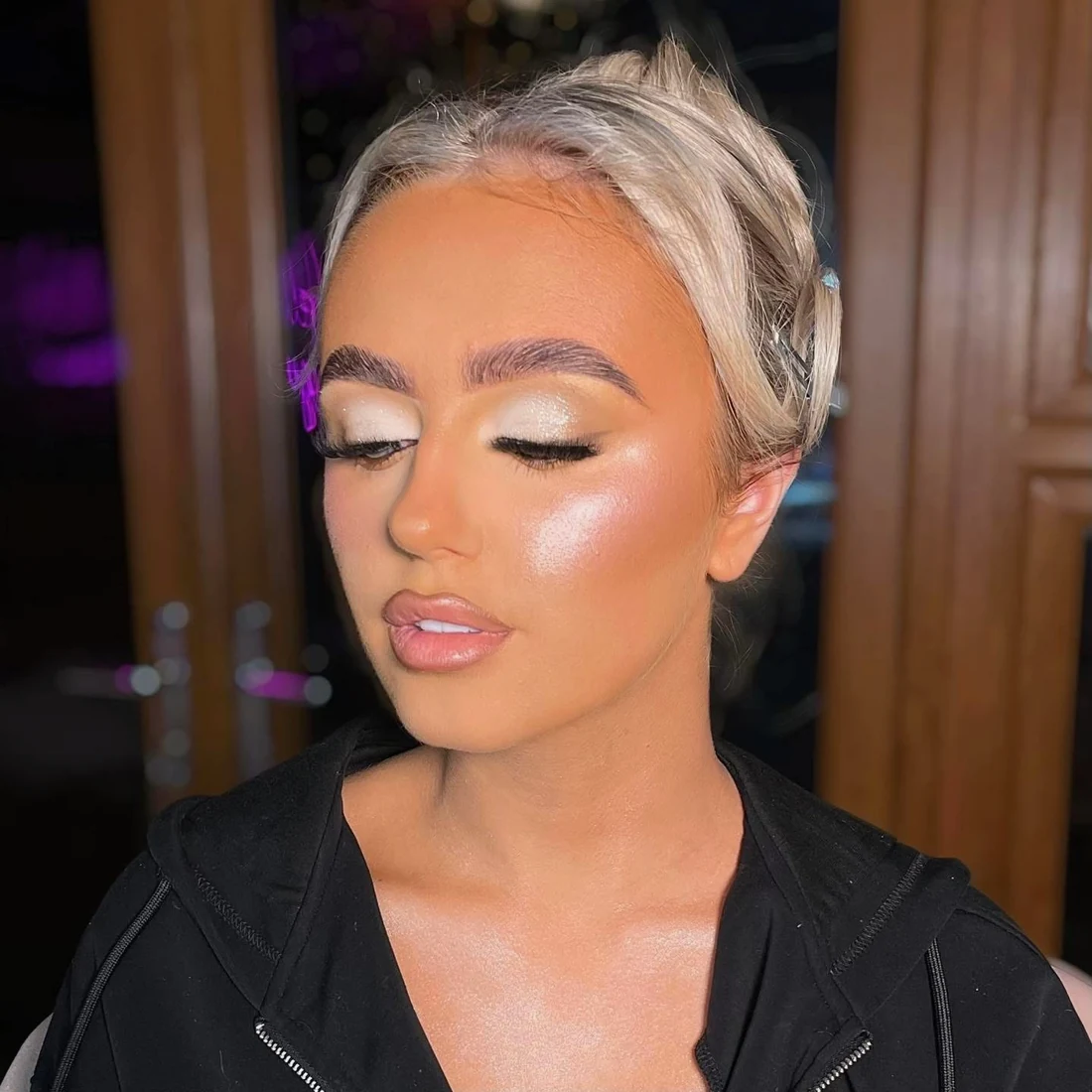 Silver shimmer eye makeup and sculpted cheeks on a blonde client
