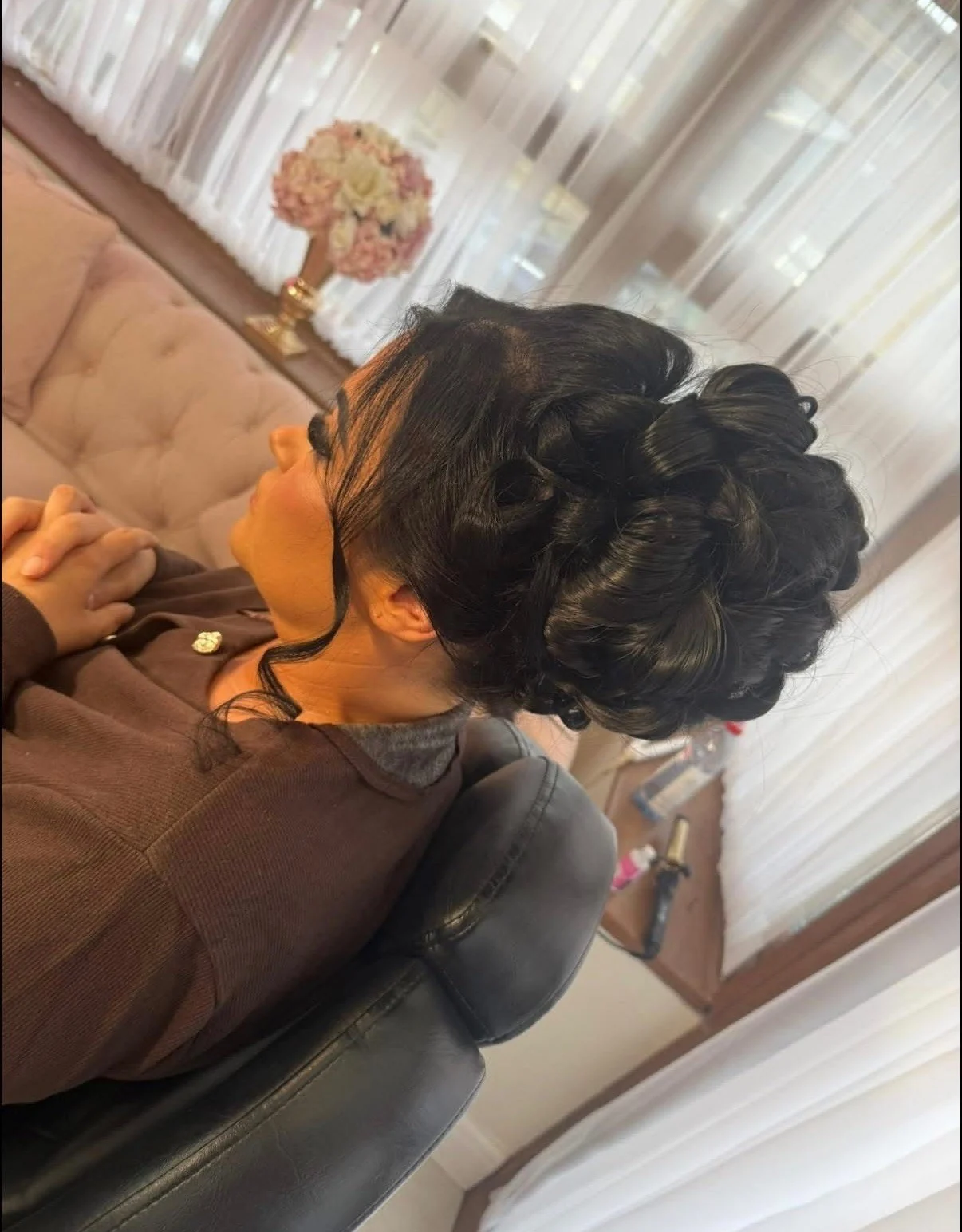 A dark updo with large pinned curls and loose face-framing strands