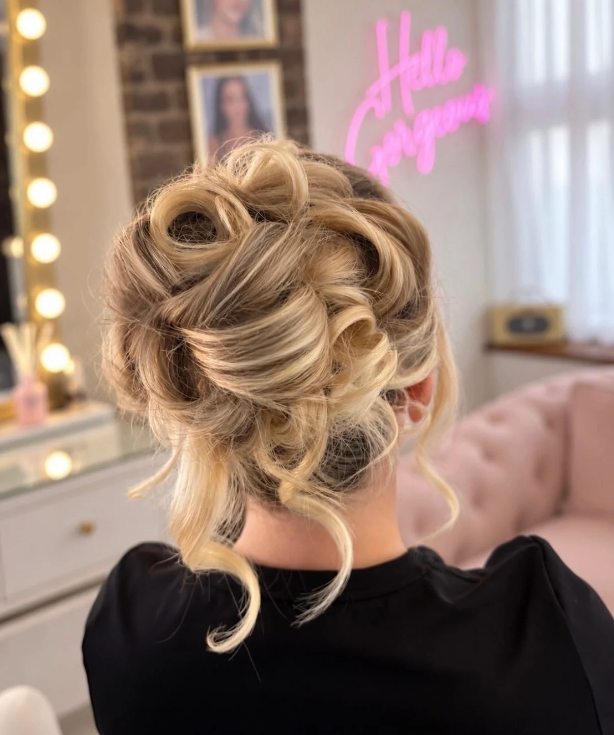 Loose blonde curls pinned into a textured updo